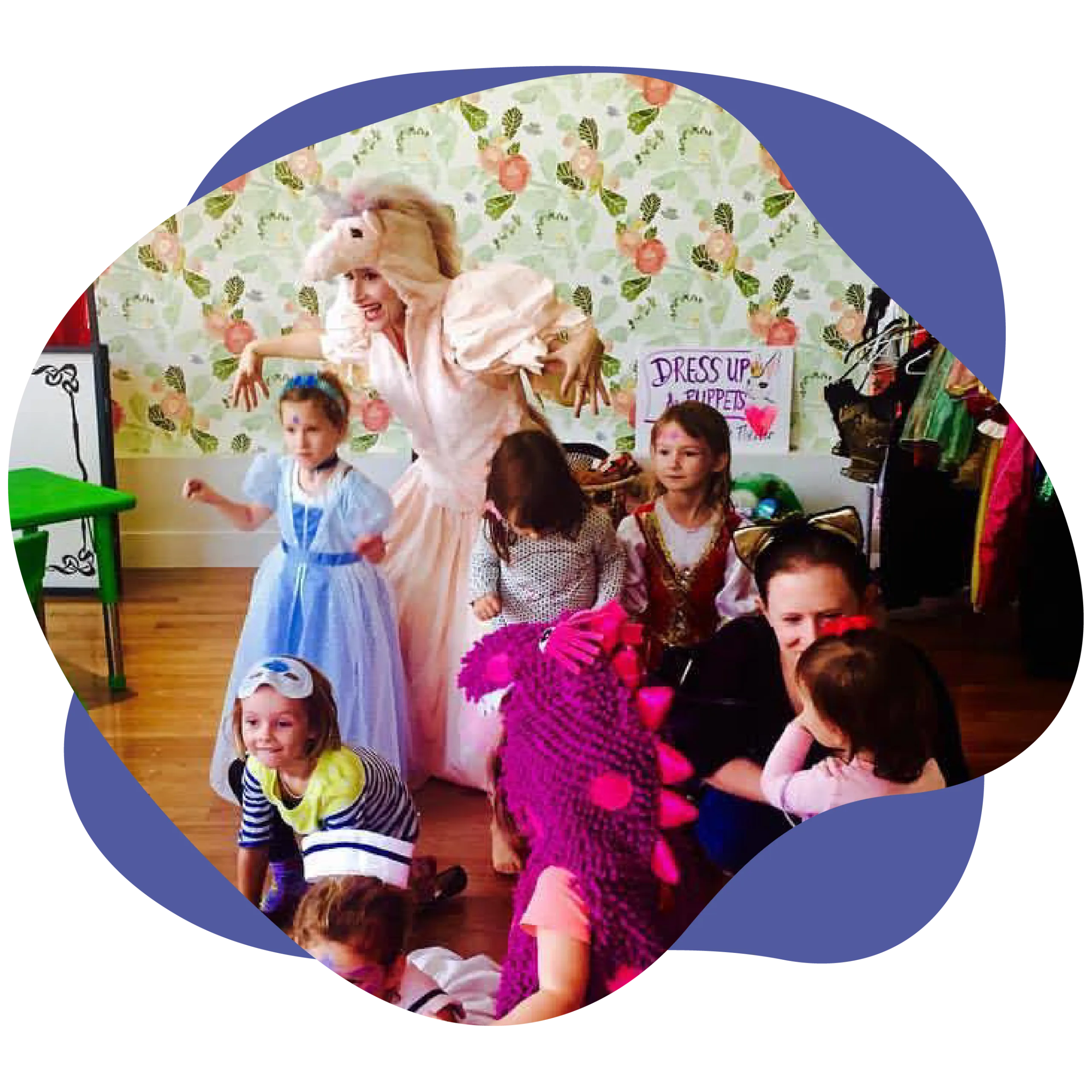 Children and an adult in costume at a themed dress-up party with a colorful floral backdrop, embodying the spirit of creativity that inspires those longing to join our team.